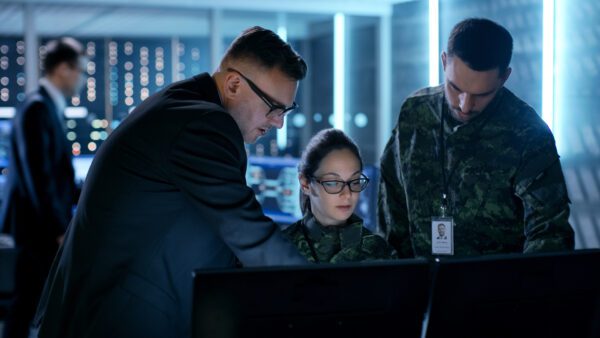 Military staff attentively looking at a laptop